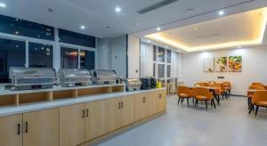 a restaurant with a waiting area with tables and chairs at Shell Hotel Wuxi Gonghu Avenue Vientiane City in Zhongqiao