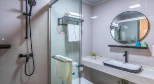 a bathroom with a shower and a sink and a mirror at Shell Hotel Wuxi Gonghu Avenue Vientiane City in Zhongqiao