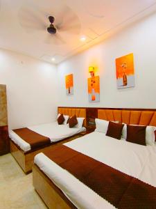 two beds in a room with paintings on the wall at Pushpa Homestay in Varanasi