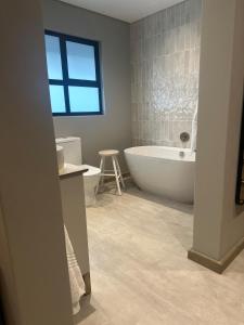 a bathroom with a tub and a toilet and a sink at Fallen Oak Villa 2 in George +33 photos