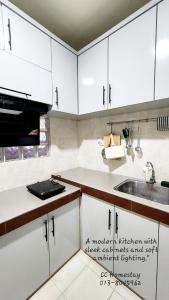 Place to stay kuching的带白色橱柜和水槽的厨房