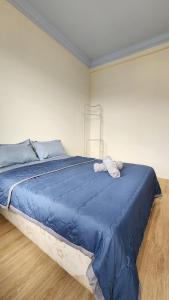 Place to stay kuching的房间里有一张床和一条蓝色的被子