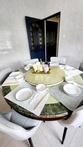 Place to stay kuching的一张大桌子，配白色椅子和一张桌子