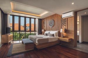 ein Schlafzimmer mit einem großen Bett und einem großen Fenster in der Unterkunft Teratai Villa Canggu by Ini Vie Hospitality in Canggu