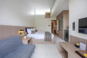 a hotel room with a bed and a couch at Bali True Living in Denpasar