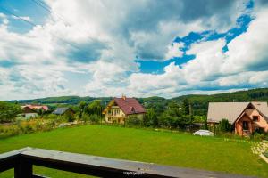 a view of a yard with houses and a green field at Domki na Szczycie - balia jacuzzi na wyłączność in Krzeszna