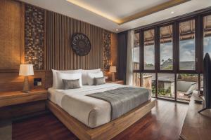 ein Schlafzimmer mit einem großen Bett und einem großen Fenster in der Unterkunft Teratai Villa Canggu by Ini Vie Hospitality in Canggu