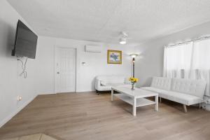 a living room with a white couch and a tv at Charming House Free RV Parking in Upland