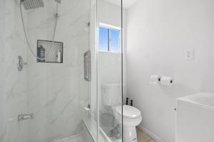 a white bathroom with a shower and a toilet at Charming House Free RV Parking in Upland