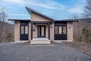 a small house with a driveway at Ski in - Ski out - SPA & Pool Table - Le Konect in Saint-Philémon