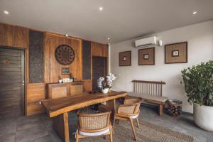 ein Esszimmer mit einem Holztisch und Stühlen in der Unterkunft Teratai Villa Canggu by Ini Vie Hospitality in Canggu