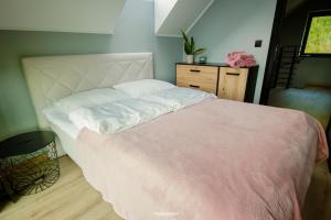 a bedroom with a large bed and a dresser at Domki na Szczycie - balia jacuzzi na wyłączność in Krzeszna +14 photos