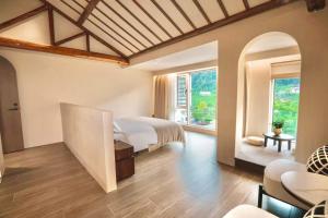 Un dormitorio con una cama y una sala de estar. en Wake Up in Mountain, en Jiawan