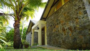 TikaliCINEC Eco Resort的一座石头建筑,旁边是棕榈树