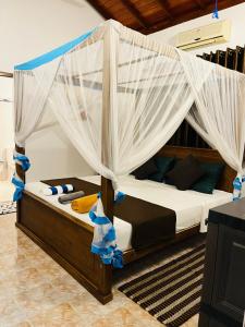 Un dormitorio con una cama con dosel y cortinas. en Hikkaduwa magnoon villa, en Hikkaduwa