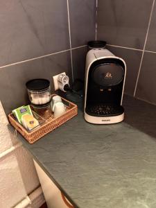 una macchinetta del caffè seduta su un bancone in cucina di Appartement au calme. a Thaon-les-Vosges 1 altra foto