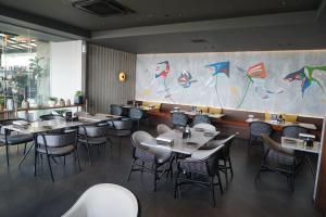 a restaurant with tables and chairs and a wall with kites at Hilltops Serviced Apartment in Semarang