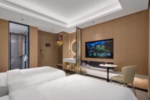 een hotelkamer met twee bedden en een tv aan de muur bij Xi'an Yunzhi Hotel in Xi'an