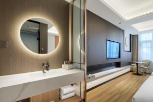 een badkamer met een wastafel en een spiegel bij Xi'an Yunzhi Hotel in Xi'an