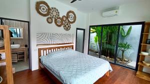 a bedroom with a bed and a large window at Sarang Jati Mansion in Ban Saiyuan (1) +28 photos