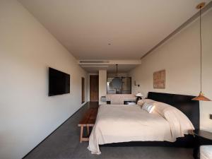 a bedroom with a large bed and a flat screen tv at Shanyu Art Garden Homestay in Fuzhou +126 photos