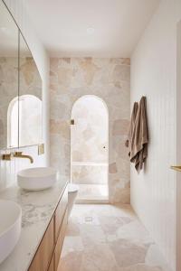 Un baño blanco con dos lavabos y un espejo. en Beachfront Bliss at Clovelly, en Clovelly