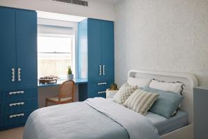 1 dormitorio con armarios azules y 1 cama con ventana en Beachfront Bliss at Clovelly, en Clovelly 15 fotos más