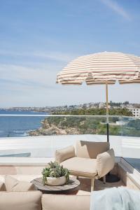 un patio con una silla y una sombrilla en Beachfront Bliss at Clovelly, en Clovelly