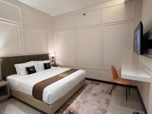 玛琅Gets Hotel Malang的带一张大床和一把椅子的卧室