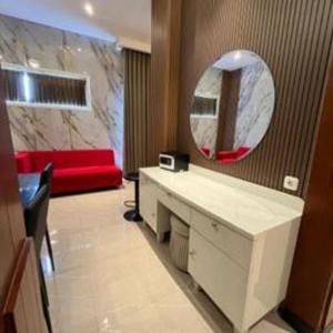 玛琅Gets Hotel Malang的浴室里有梳妆台、镜子和一张红色沙发