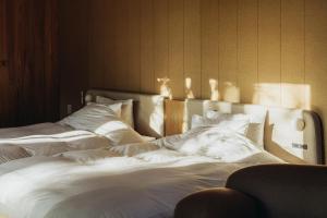 Dos camas en una habitación con sábanas y almohadas blancas. en SANU 2nd Home 河口湖2nd, en Fujikawaguchiko