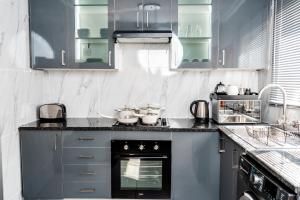 uma cozinha com armários azuis e um forno em Nexovant Furnished Apartments em Maun