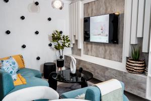 uma sala de estar com um sofá e uma TV em Nexovant Furnished Apartments em Maun