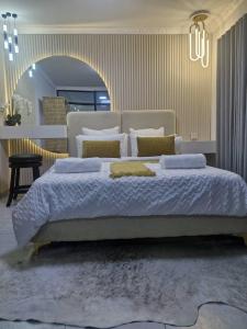 um quarto com uma cama grande e almofadas em Nexovant Furnished Apartments em Maun