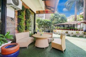 Un patio con mesa y sillas y un edificio. en FabHotel DDHYANA The Wellness Centre and Resort, en Panaji