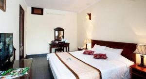 um quarto de hotel com uma cama e uma televisão em Hai Au Hotel em Ðông Thôn mais 157 fotografias