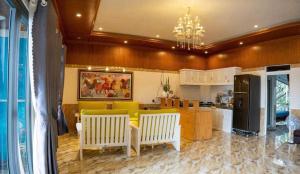 una cucina con due sedie bianche e un divano giallo di Villa mini 3 phòng ngủ Đà Lạt a Xuan An Altre 32 foto