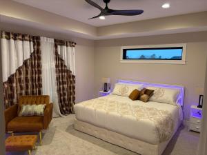 a bedroom with a bed and a chair at Luxurious Sweet Escape stunning custom Home! in Rochester