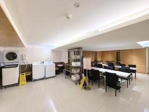 a large room with tables and chairs and a kitchen at 巴黎商旅 Paris Hotel in Kaohsiung