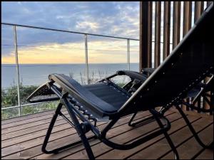 einen Stuhl auf einer Veranda mit Meerblick in der Unterkunft the SHIHACHI 