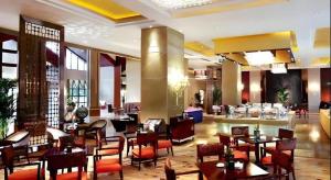 a restaurant with tables and chairs in a lobby at Xinjin Celebrity City Hotel in Xinjin