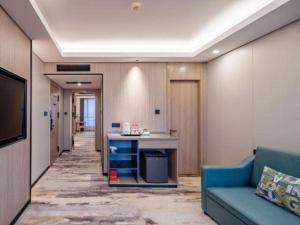 uma sala de estar com um sofá azul e uma escrivaninha em Jiaxing Fortune Holiday Hotel em Jiaxing