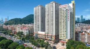a city with tall white buildings and a river at Vienna Hotel Shenzhen Longgang Baifucheng in Longgang