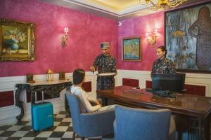 Dos hombres de pie en una habitación con una mujer sentada en una mesa. en The Manor Sports and Wellness Hotel, en Nāldera 86 fotos más