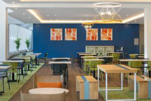 モントリオールにあるSpark By Hilton Montreal Midtownのテーブルと椅子と青い壁のあるレストラン
