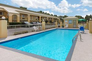 a swimming pool in front of a hotel with a building at Quality Inn McComb in McComb
