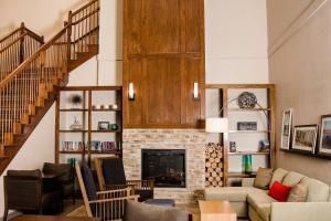 a living room with a staircase and a fireplace at Country Inn & Suites by Radisson, Winchester, VA in Winchester