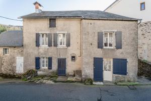 ein altes Haus mit blauen Türen und Fenstern in der Unterkunft Appart centre La Salvetat Agout in La Salvetat