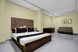 um quarto com uma cama grande e um sofá em - Hotel O Machilipatnam Railway Station Formerly Hasini Celebrations em Machilīpatnam mais 21 fotografias