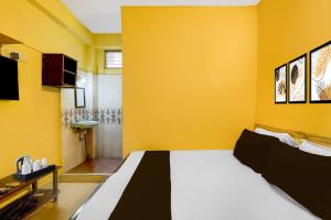 钦奈Super Hotel O Egmore Metro Station Chennai Formerly Harini Lodge的黄色的房间,设有床和黄色的墙壁